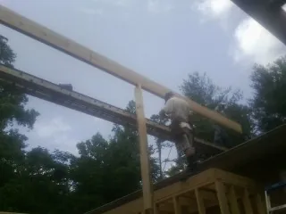 Carpenter setting a ridge beam over a new addition frame — Ice Dam Removal by Roofing Brothers in Ingomar